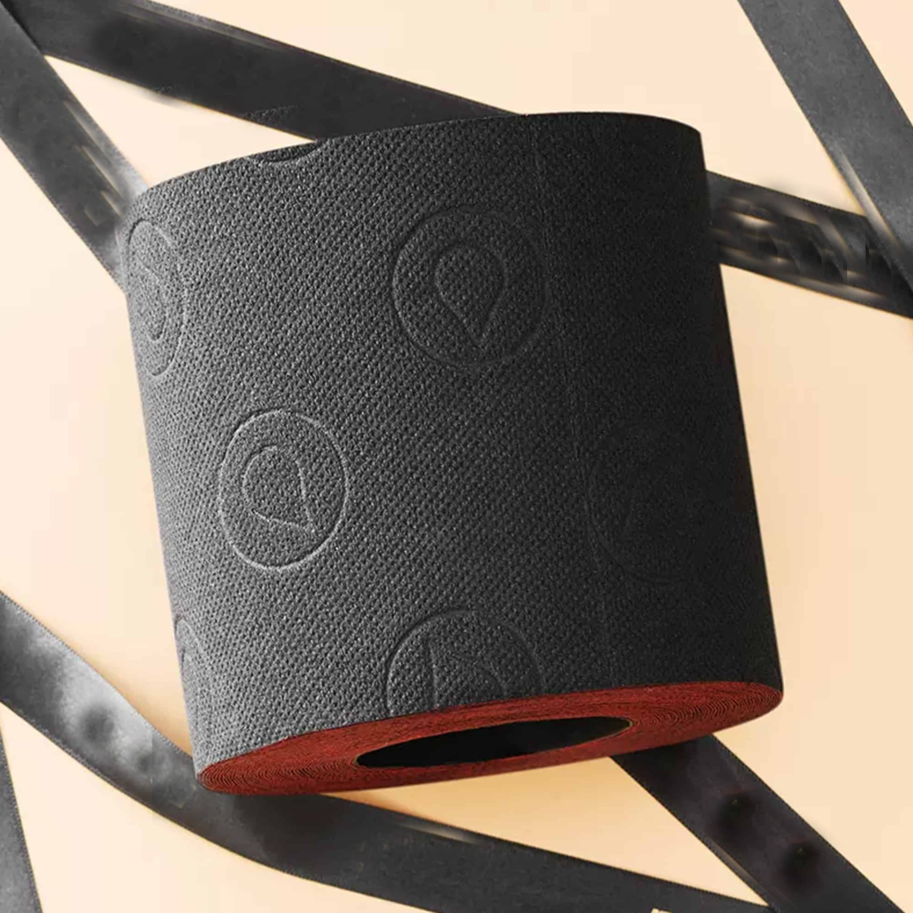 Black foam roller with embossed circular patterns on a wooden surface.